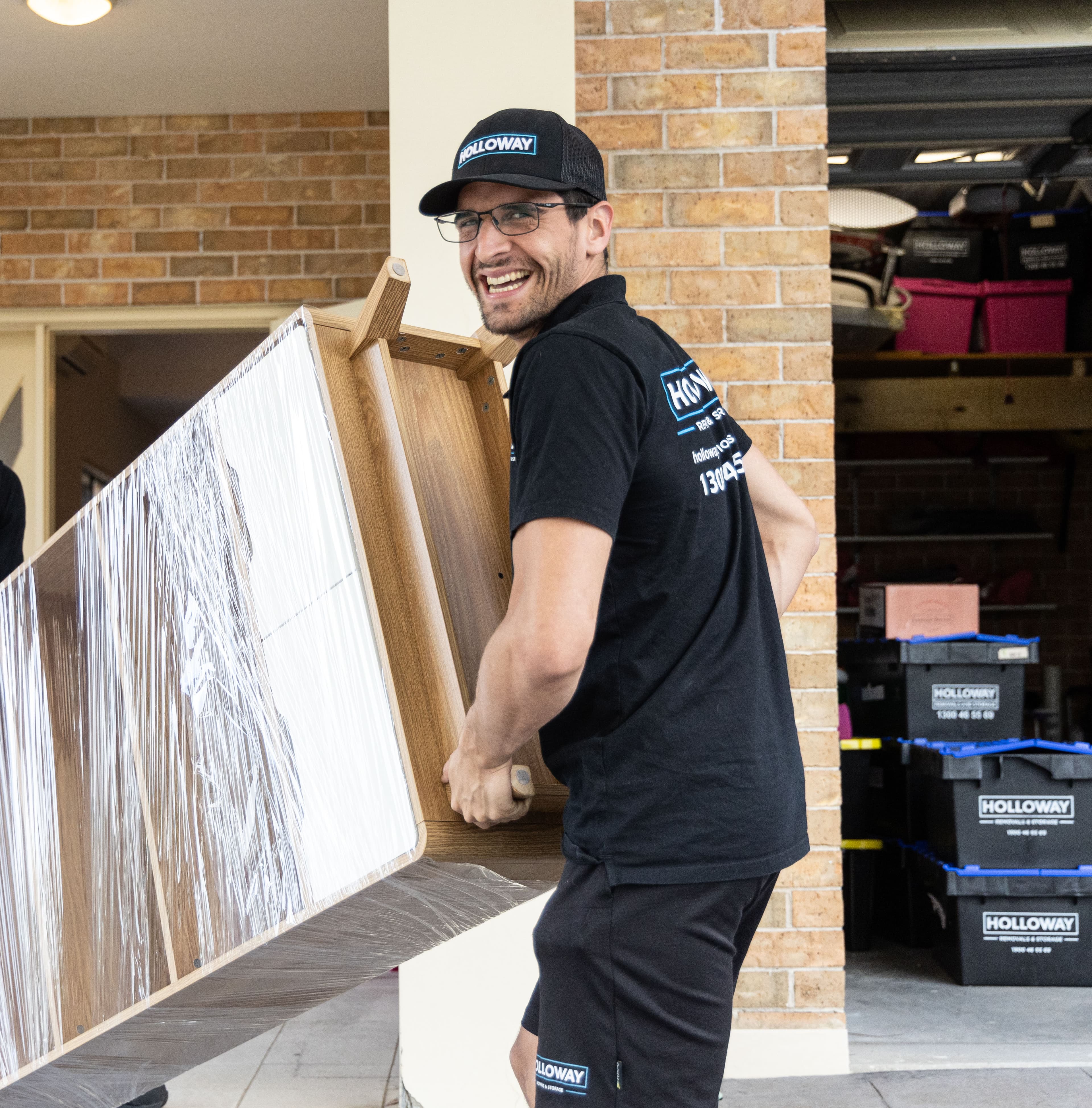 Holloway team moving a cabinet wrapped and protected in shrink wrap